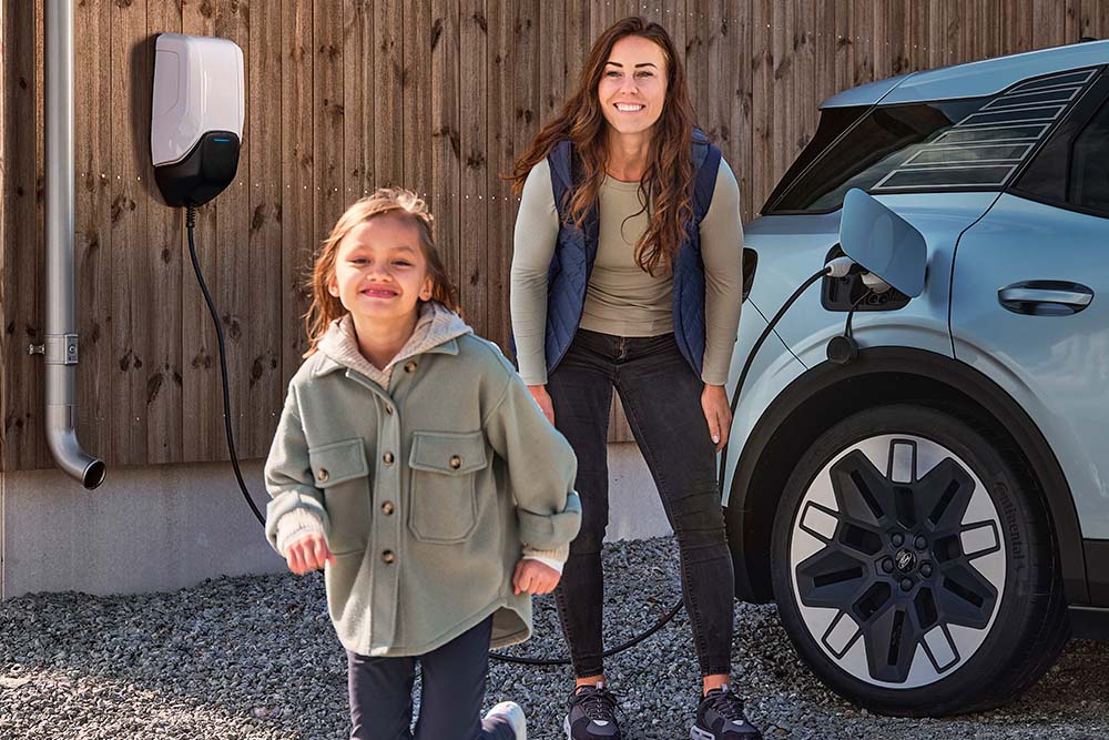 Une famille s'amusant à recharger son Ford Explorer électrique à la maison.