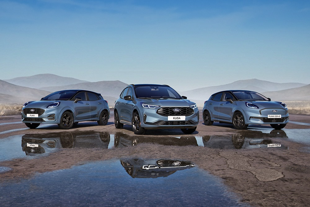 Un Ford Puma, un Ford Kuga et un  Ford Puma Gen-E garés sur une route humide avec des montagnes en arrière-plan.