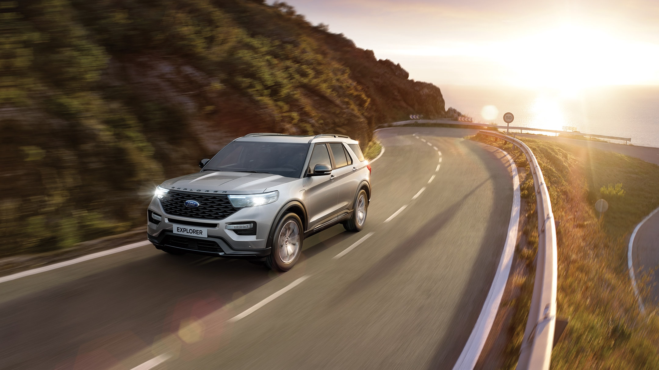 Ford Explorer driving in sun drenched country