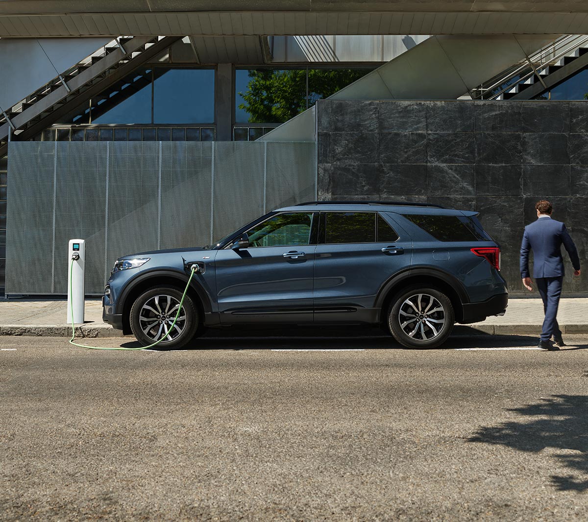 Un homme a coté du Ford Explorer et d’une borne de recharge