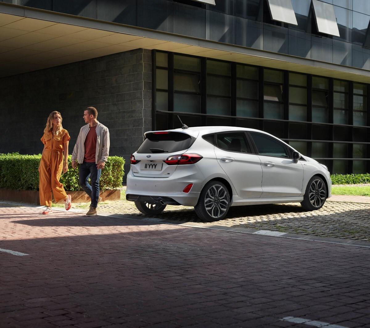 Ford Fiesta rear three quarter view with two people beside it