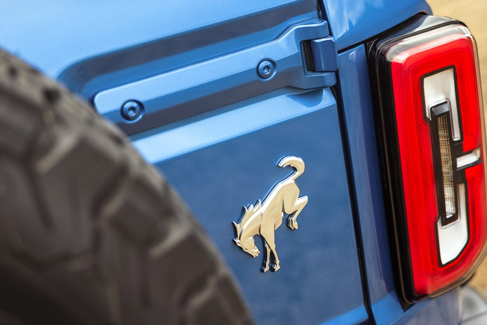 Gros plan sur les détails de la marque à l’arrière d’un Ford Bronco bleu.