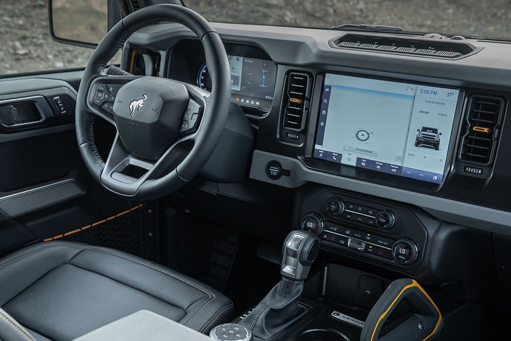 Vue de l’intérieur du Ford Bronco, avec le volant en cuir et le pavé tactile connecté.