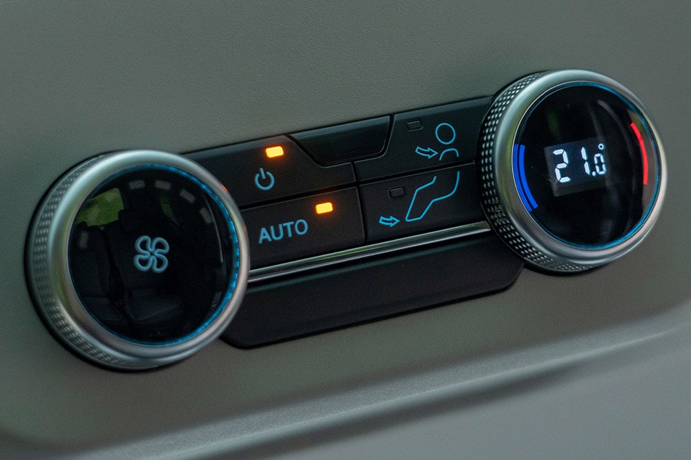 Gros plan sur les commandes de climatisation du véhicule.