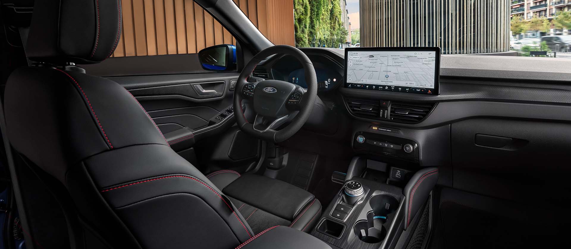 Intérieur d'un Ford Kuga, montrant le tableau de bord, le volant et le grand écran tactile central.
