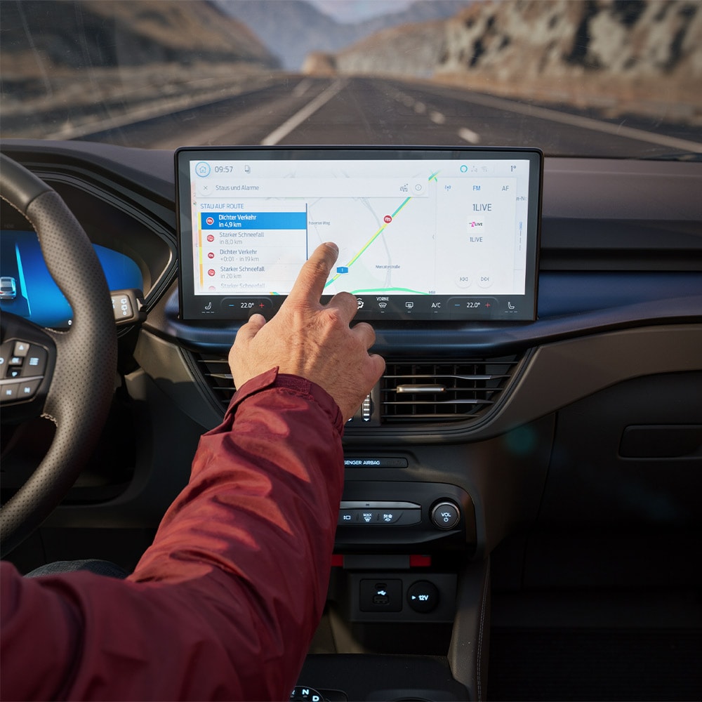 Un conducteur utilisant la fonctionnalité de Navigation Connectée sur l’écran numérique d’un Ford KugaBlueCruise Edition.