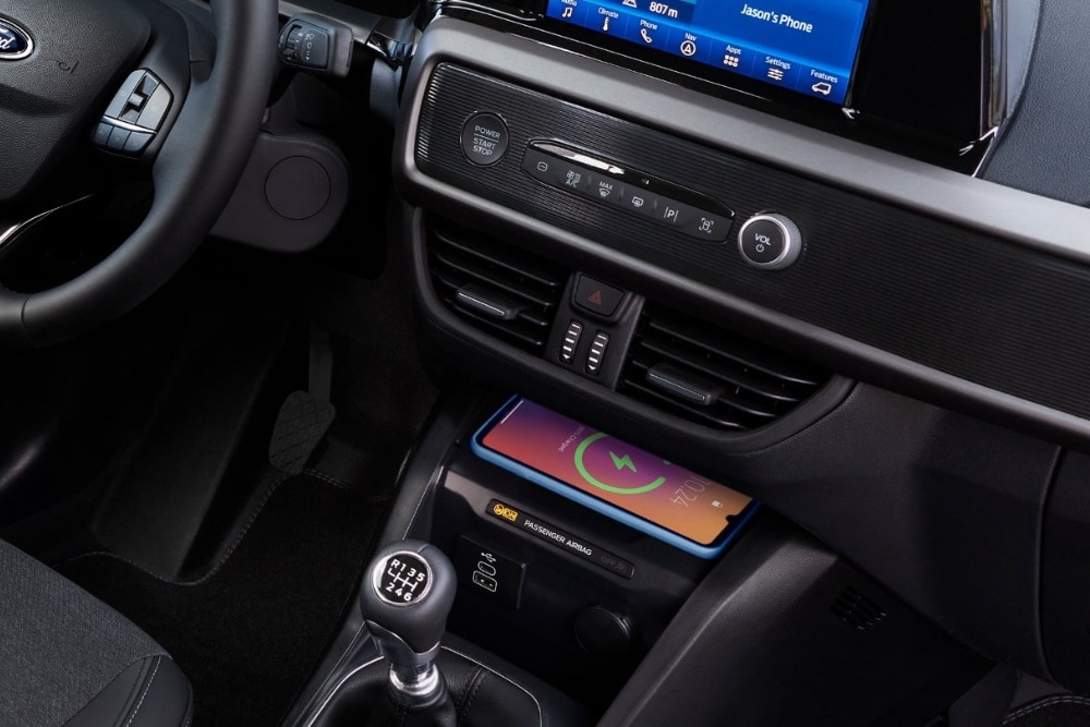 Un téléphone portable posé sur la zone de recharge sans fil du Ford Tourneo Courier.