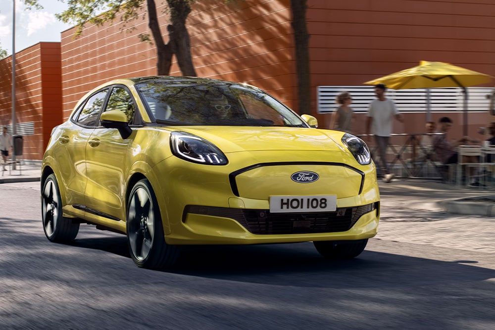 Vue avant d’un Ford Puma Gen-E® électrique jaune circulant en ville.