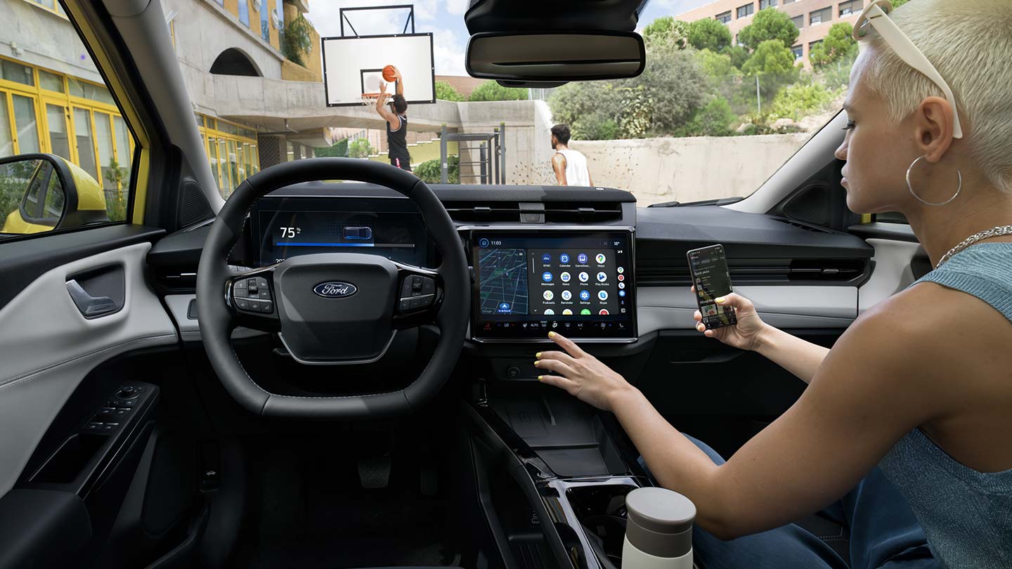 L’intérieur du Ford Puma Gen-E® électrique, avec une personne qui synchronise sans fil son téléphone à l’écran tactile.