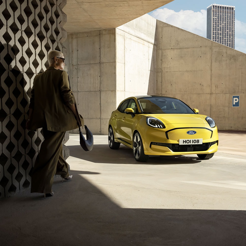 A person walks towards the new electric Ford Puma Gen-E® in yellow.