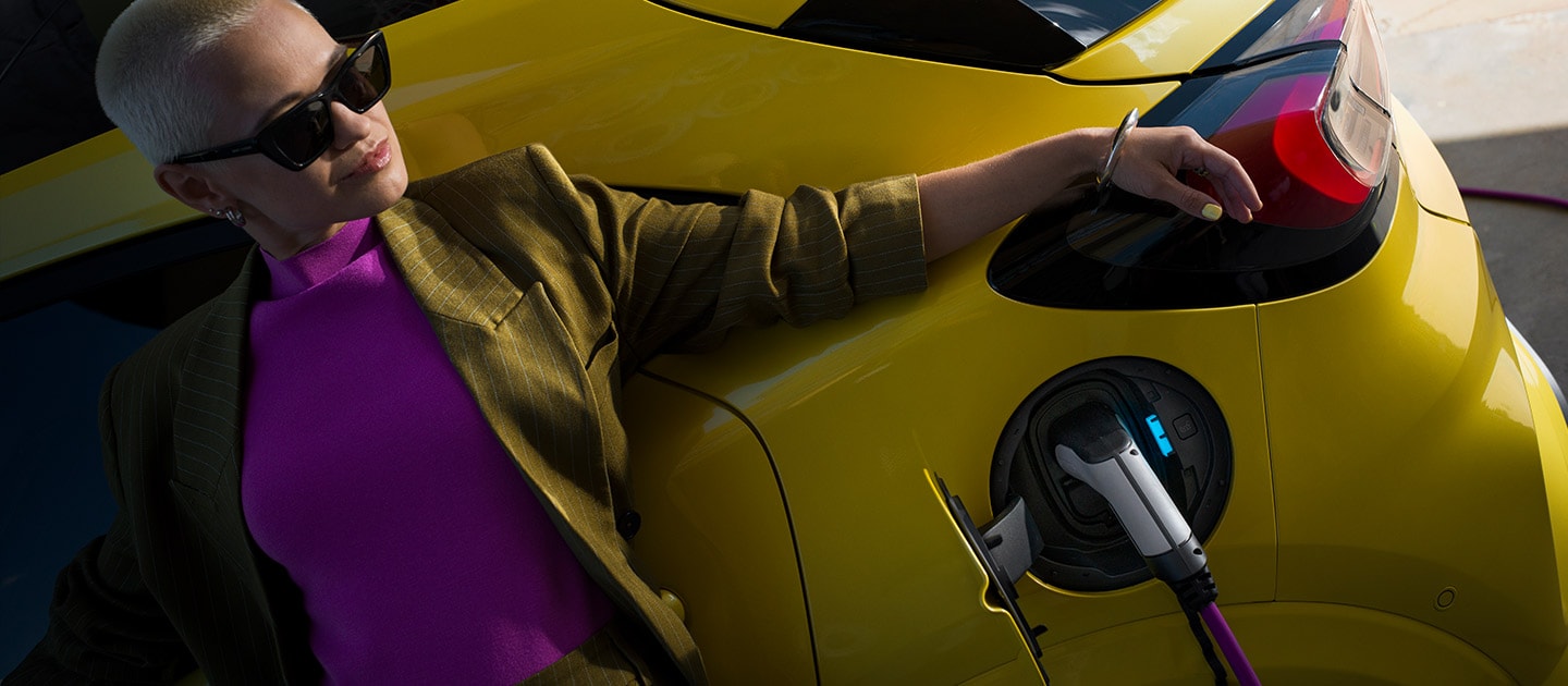 Un gros plan de l’arrière de la Ford Puma Gen-E® électrique, branchée à une borne de recharge murale à domicile.