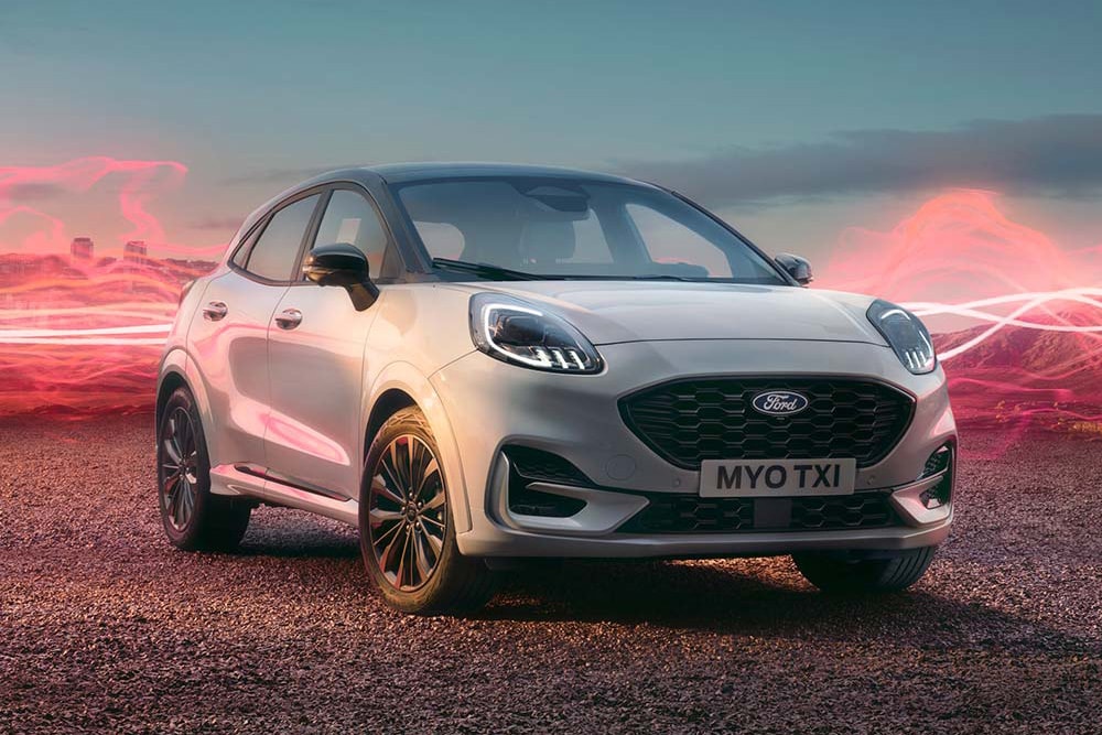 Le modèle Ford Puma Sound Edition en blanc, garé avec des ondes sonores rouges en arrière-plan.