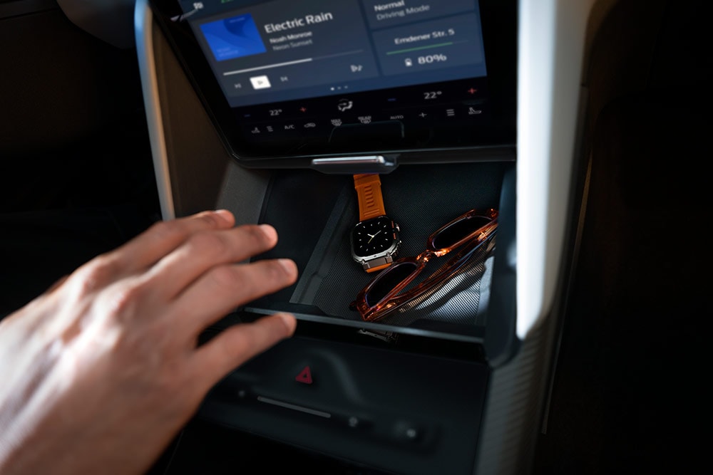 Une main se dirige vers le compartiment My Private Locker (casier secret) dans le Ford Capri®, dévoilant une montre et une paire de lunettes de soleil à l’intérieur.