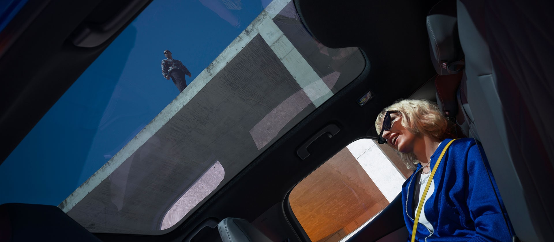 Une personne assise à l'intérieur du nouveau Ford Capri® profite du toit panoramique en verre.