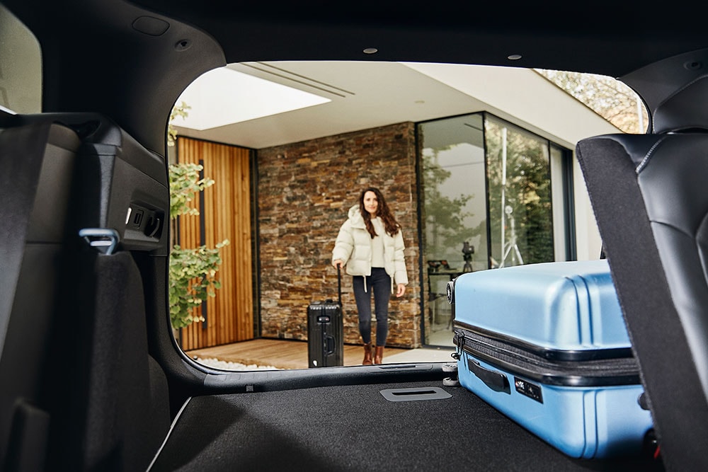 L'espace à bagages arrière du Ford Explorer, vu de l'intérieur, avec une valise bleue.