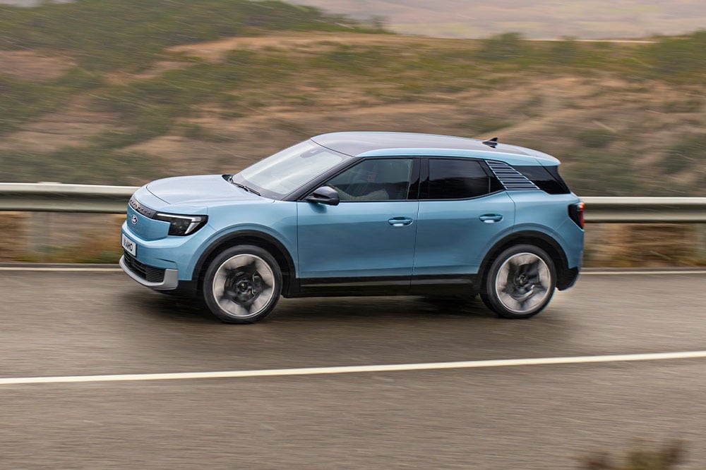 Un Ford Explorer bleu roulant sur une route de montagne.