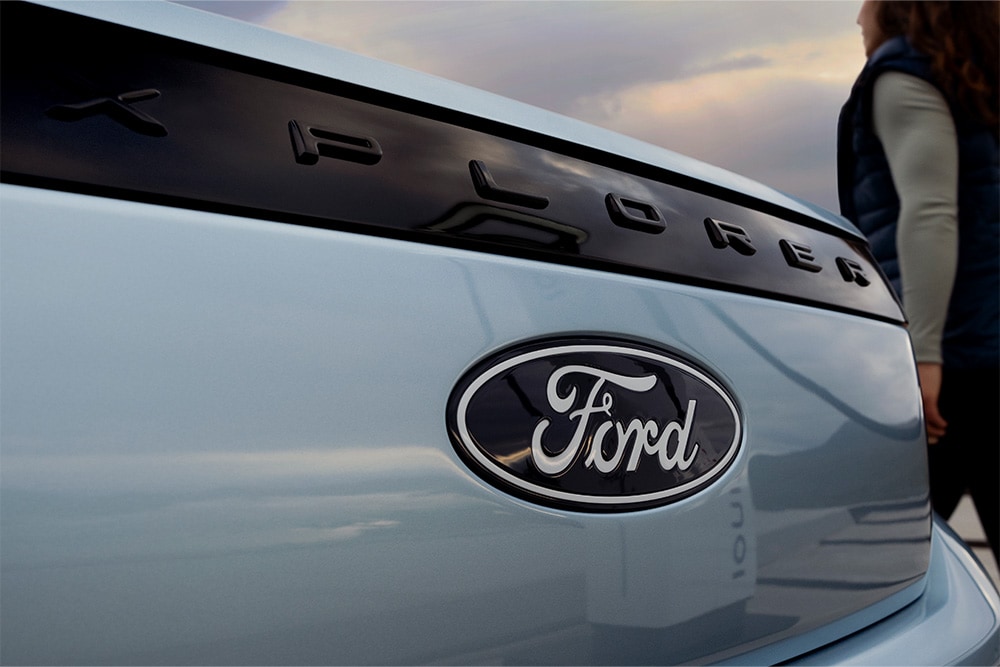 Gros plan sur l'arrière d'un Ford Explorer bleu clair, montrant le badge Ford et le lettrage « EXPLORER ».