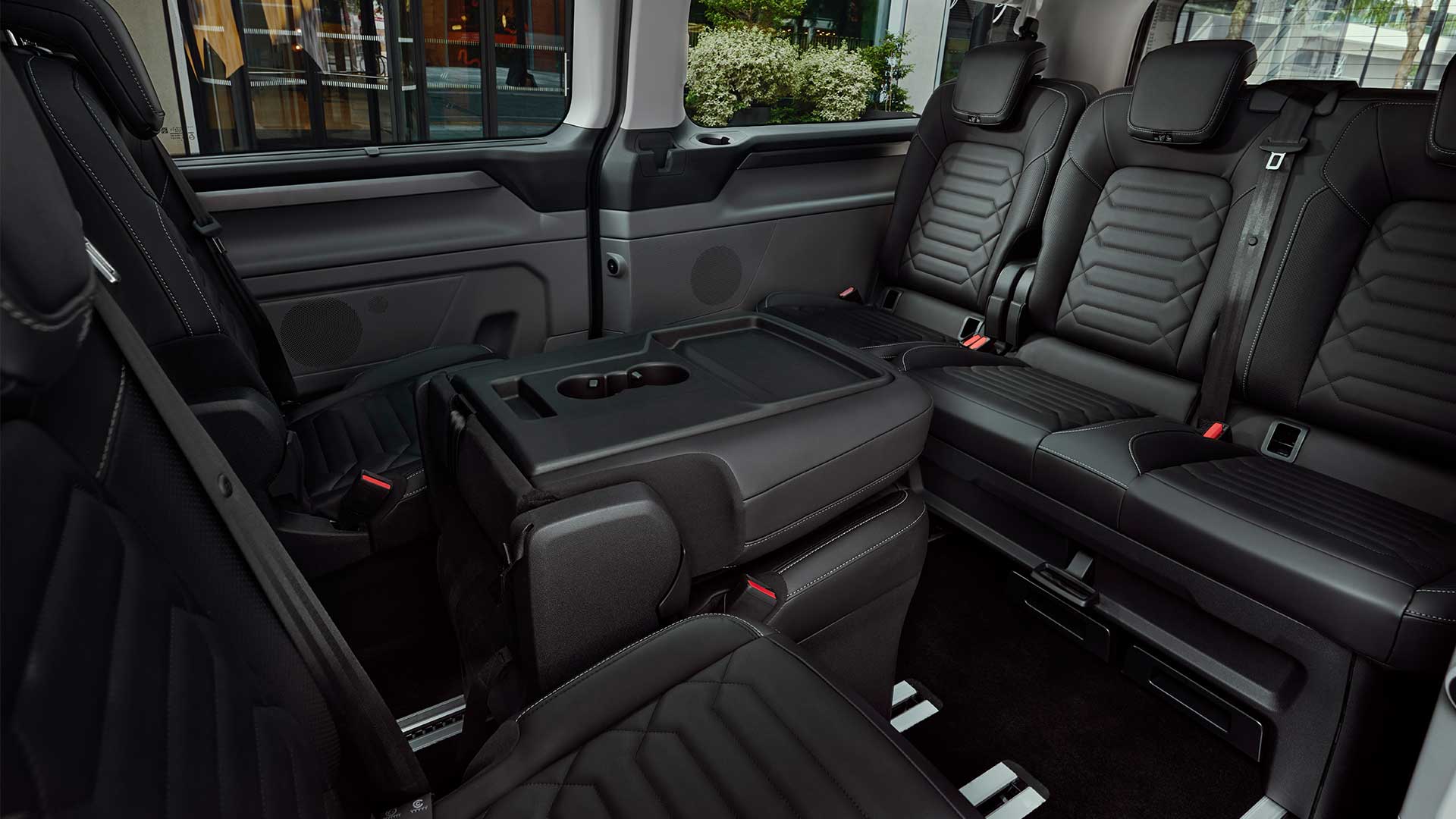 Intérieur du Ford Tourneo Custom montrant les sièges flexibles et une petite table.