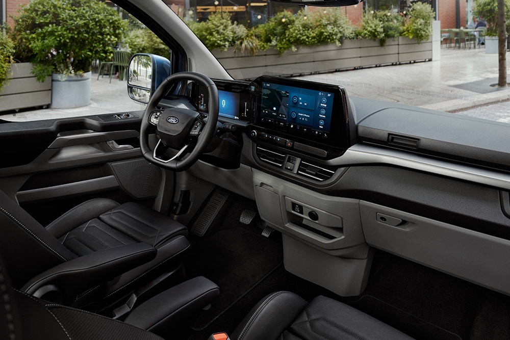 L’intérieur du Ford Tourneo Custom, montrant le siège du conducteur, le tableau de bord et la console centrale.