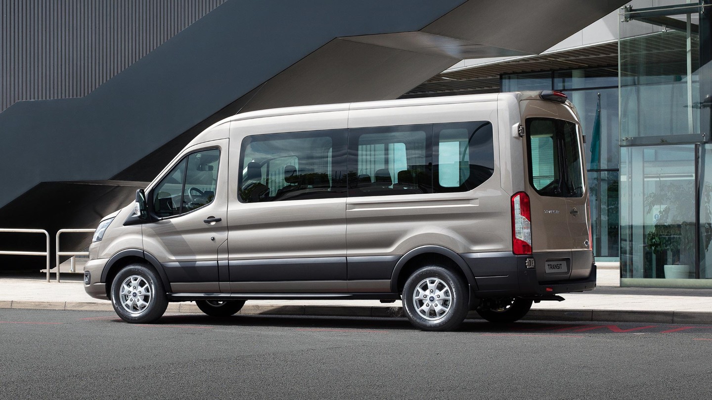 Ford Transit Kombi parking next to modern building side view