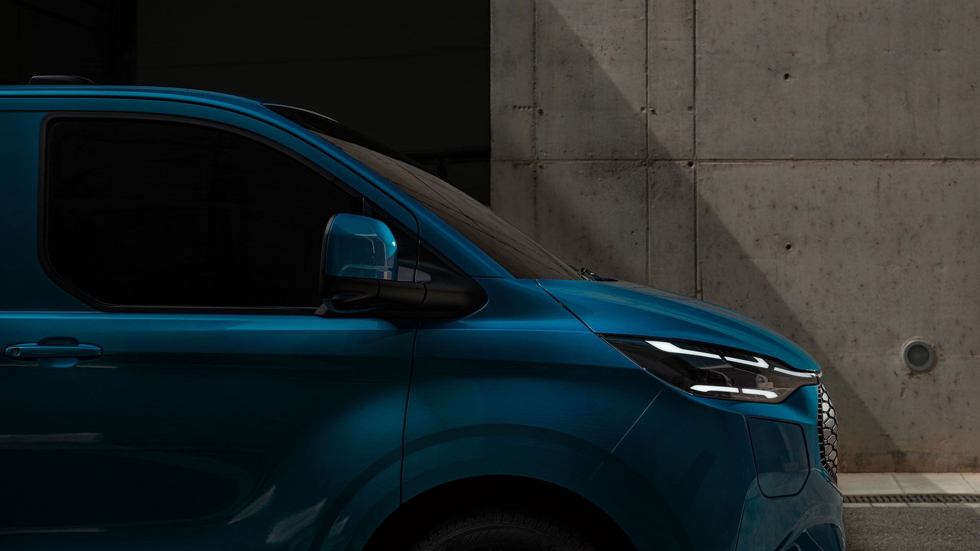 Gros plan des phares LED d'un Ford E-Transit Custom bleu.