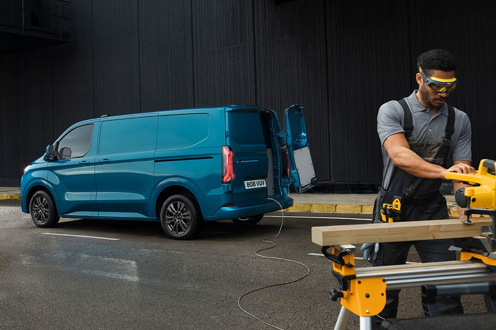 Fourgon Ford Transit Custom bleu et une personne qui utilise de l'outillage électrique.