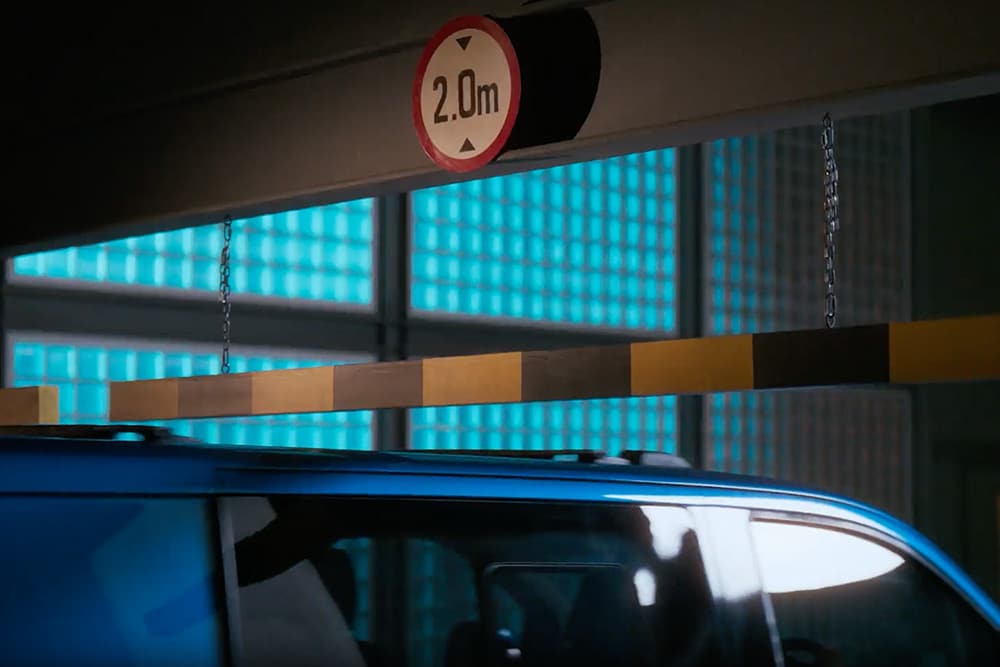 Un Ford Transit Custom bleu entre dans un parking couvert.