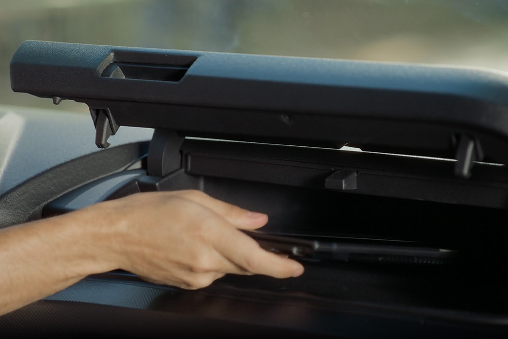 Une main ouvre un compartiment de rangement dans un Ford Transit Custom.