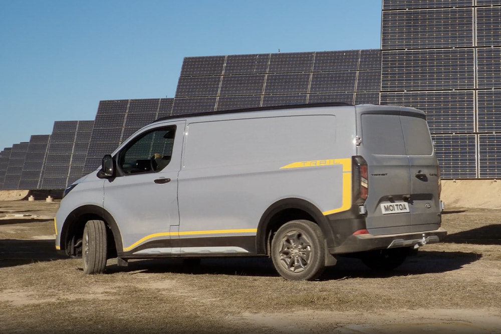 Fourgon Ford Transit Custom Trail gris avec des touches de jaune.