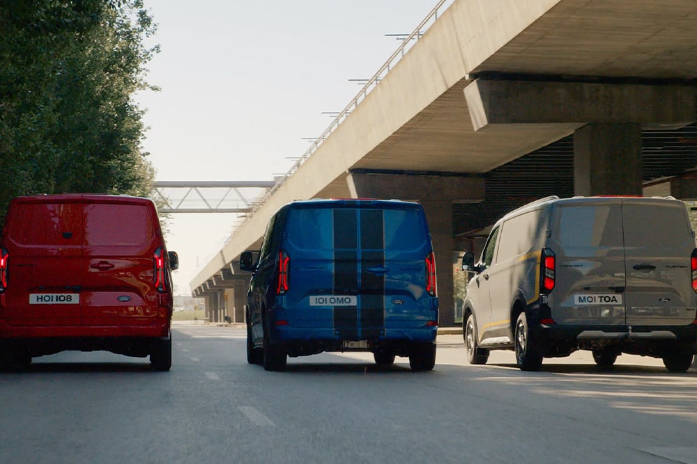 Trois fourgons Ford Transit Custom roulent sur une grande route.