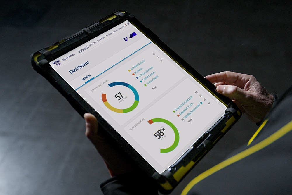 Une personne tient une tablette affichant les données d'un véhicule Ford Pro.