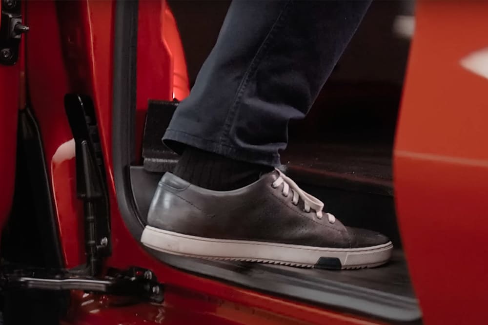 Un pied monte dans un Ford Transit Custom rouge.