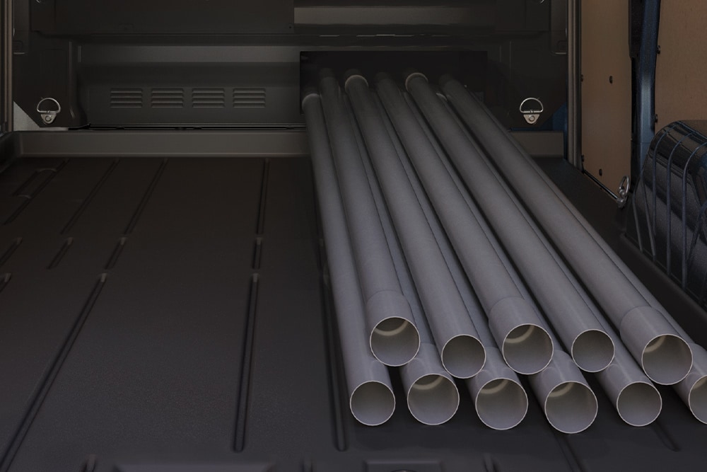 Des tubes chargés à l’intérieur d’un fourgon électrique Ford E-Transit Custom.