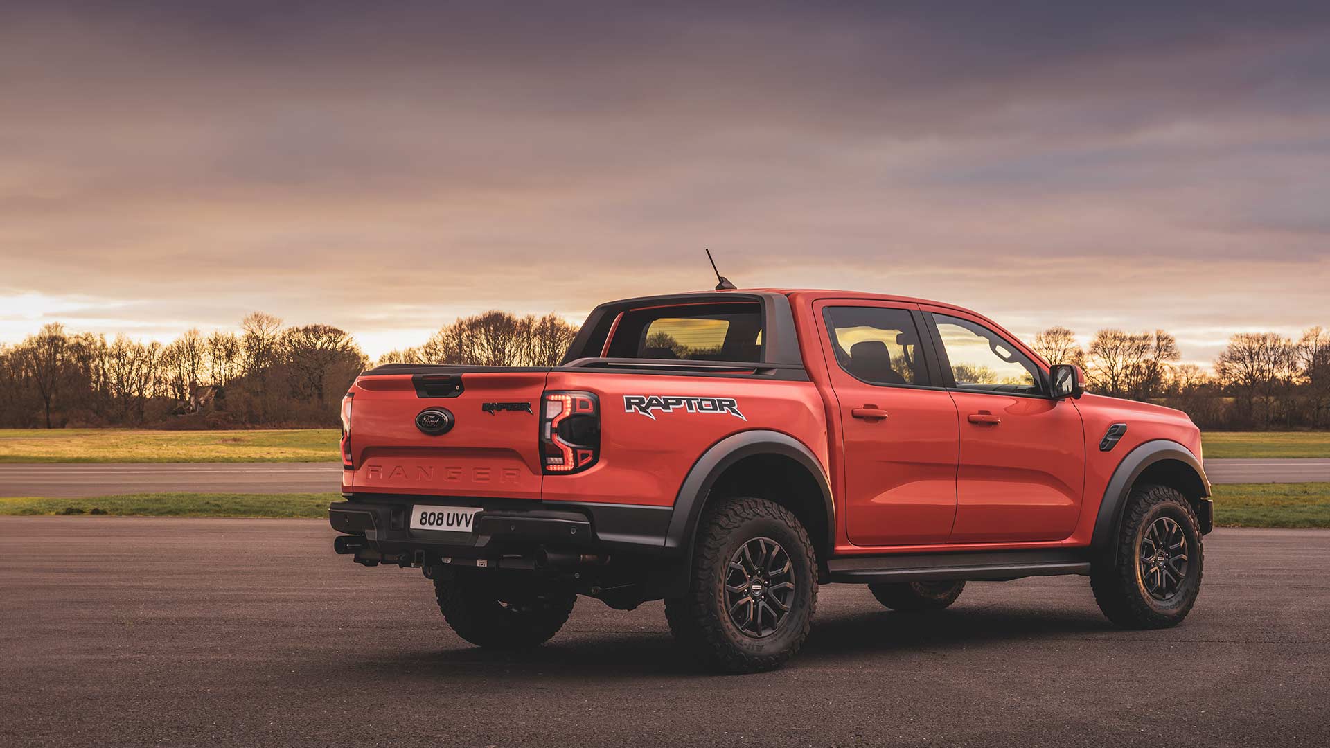 Vue arrière du Ford Ranger Raptor orange roulant sur piste.