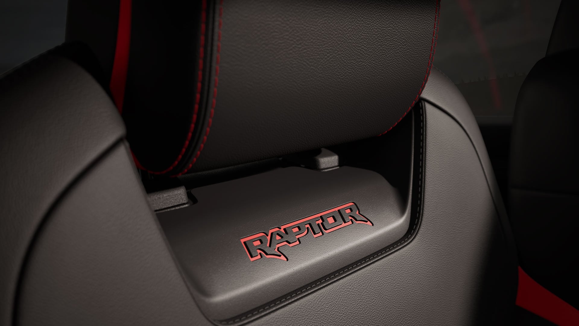 Gros plan sur le logo Raptor rouge sur un siège noir.