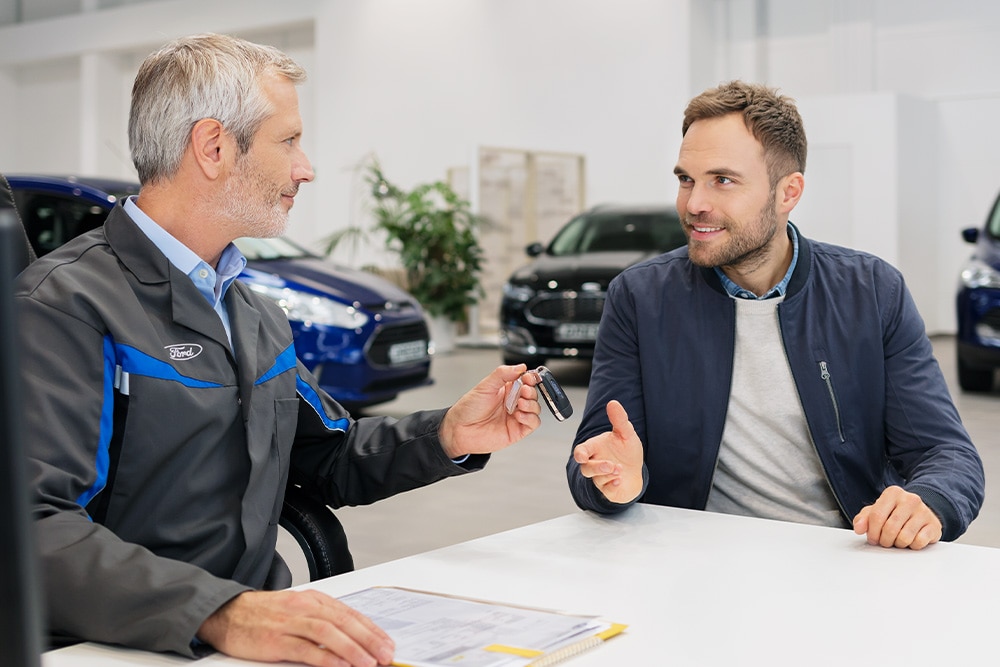 Two people in Ford dealership discussing