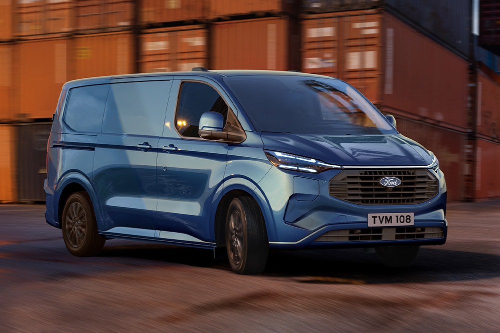 Un fourgon Ford Transit Custom Plug-in Hybrid bleu roule sur les quais d'un port.