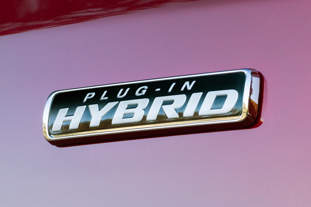 Plaque « Plug-in Hybrid » sur un Ford Transit Custom rouge.