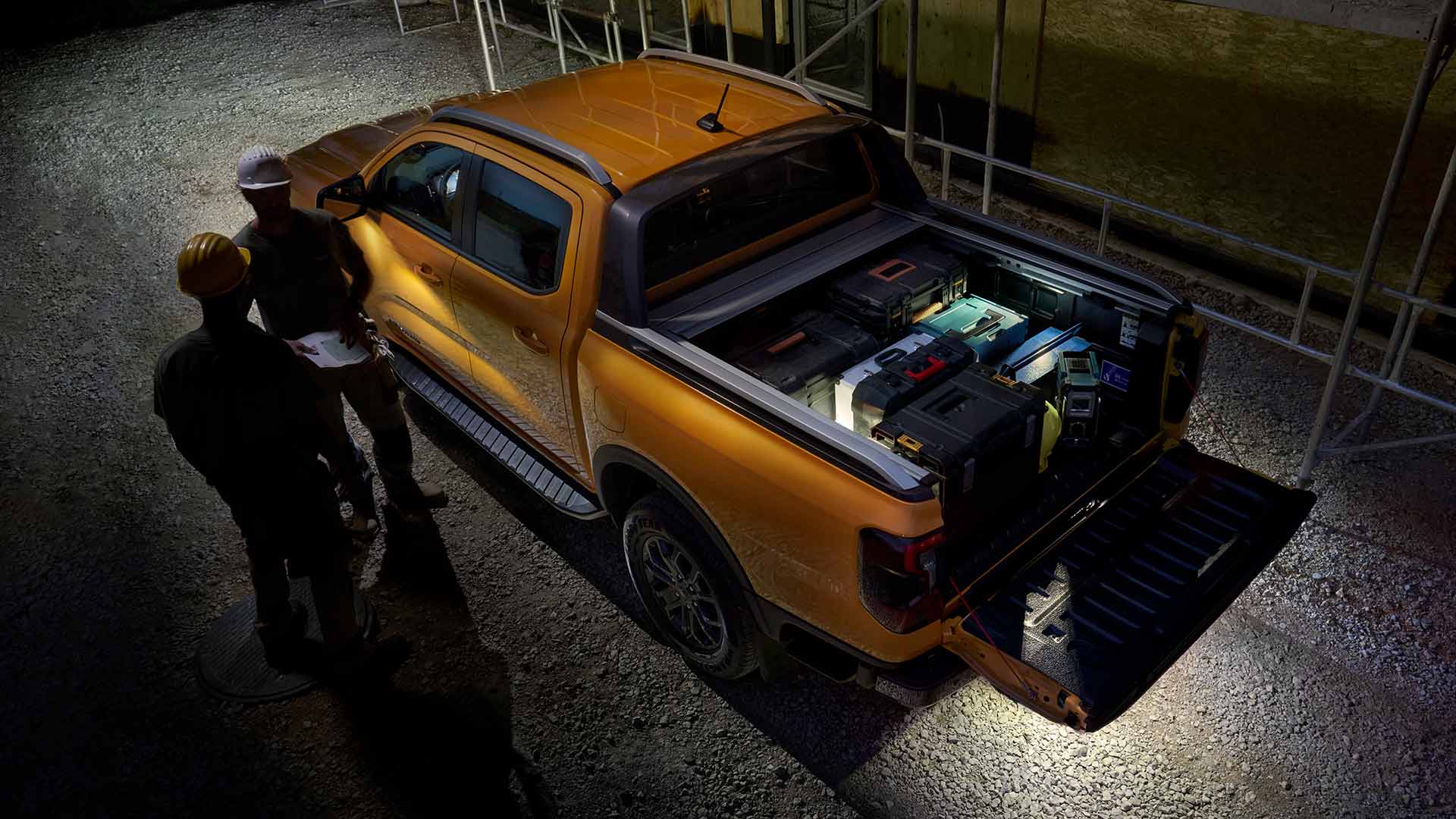 Vue aérienne nocturne du Ford Ranger Wildtrak jaune mettant en valeur l'éclairage de zone.