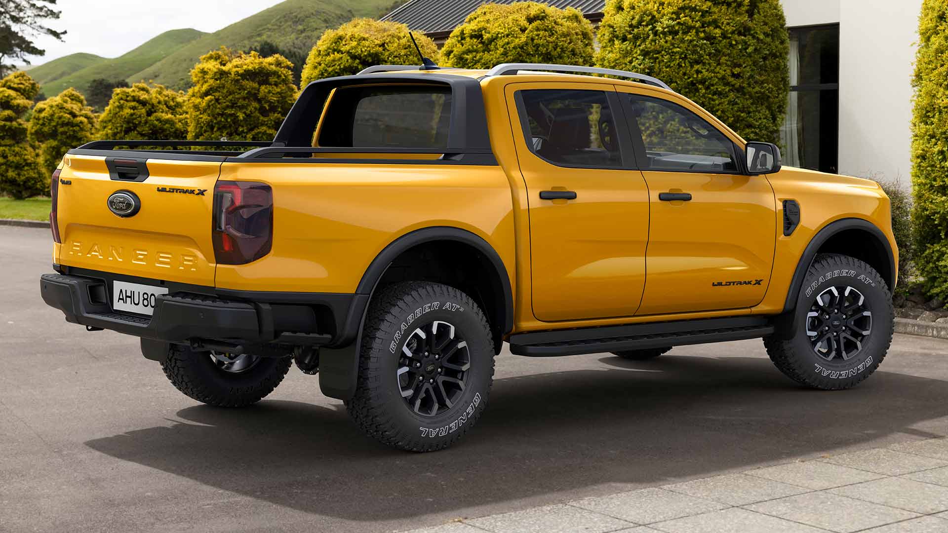 Ford Ranger Double Cabine jaune garé sur une allée pavée.