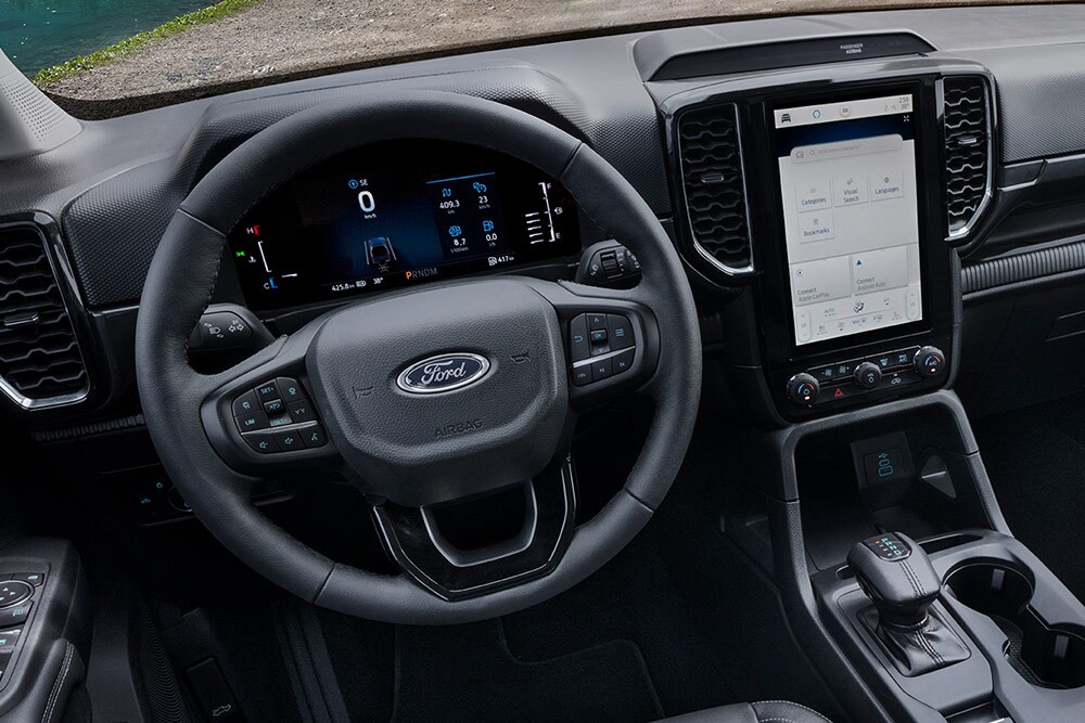 Vue intérieure du Ford Ranger Wildtrak montrant le volant et l'écran tactile SYNC™ 4 de 12 pouces de la console centrale.