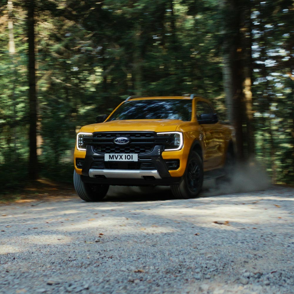 Vidéo d'un Ford Ranger Wildtrak Double Cabine jaune roulant sur des routes de montagne et des sentiers de gravier.