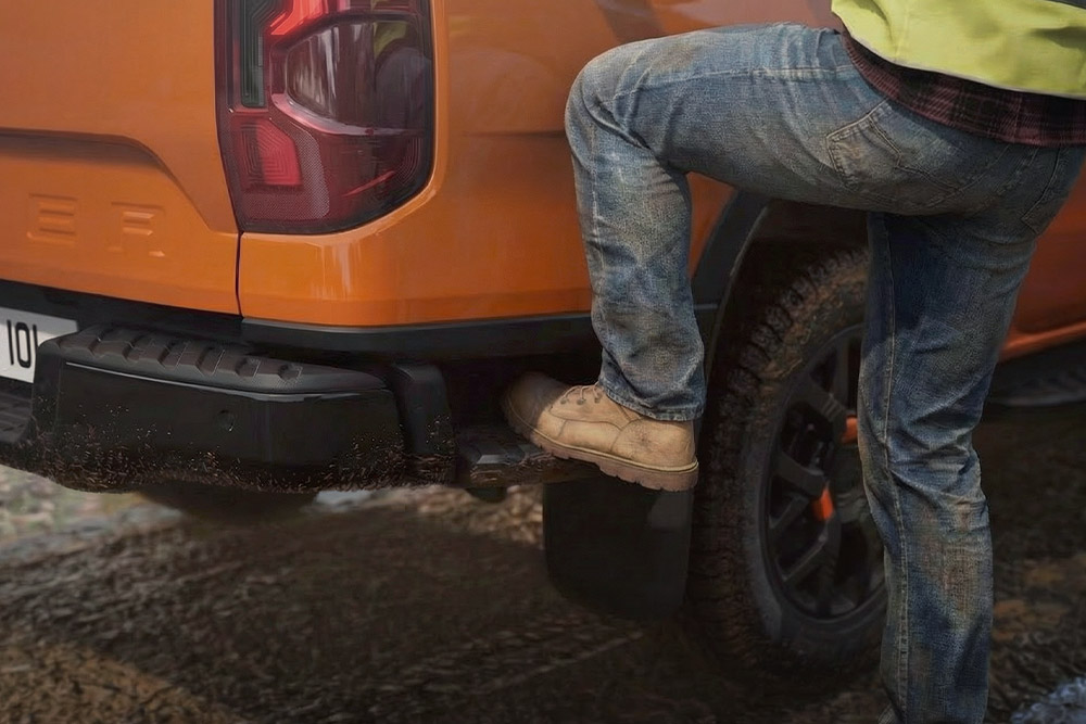 Travailleur montant sur le marchepied arrière intégré du Ford Ranger Wildtrak.