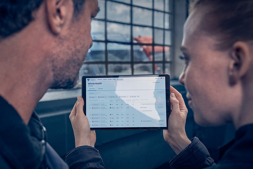 Un homme et une femme regardant ensemble un écran de tablette.