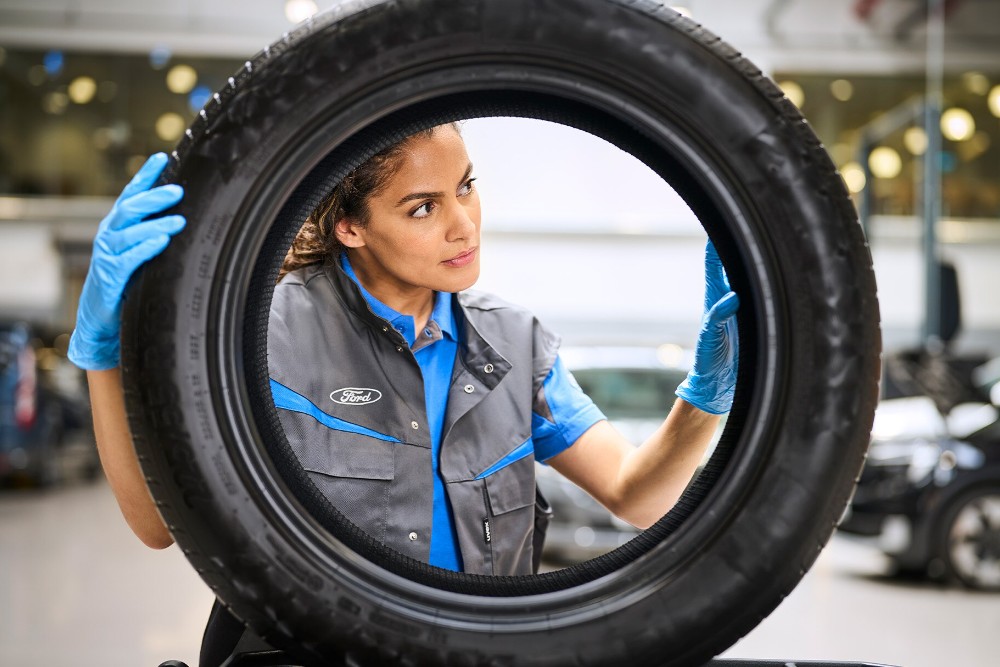 Ford mechanic holding a tyre