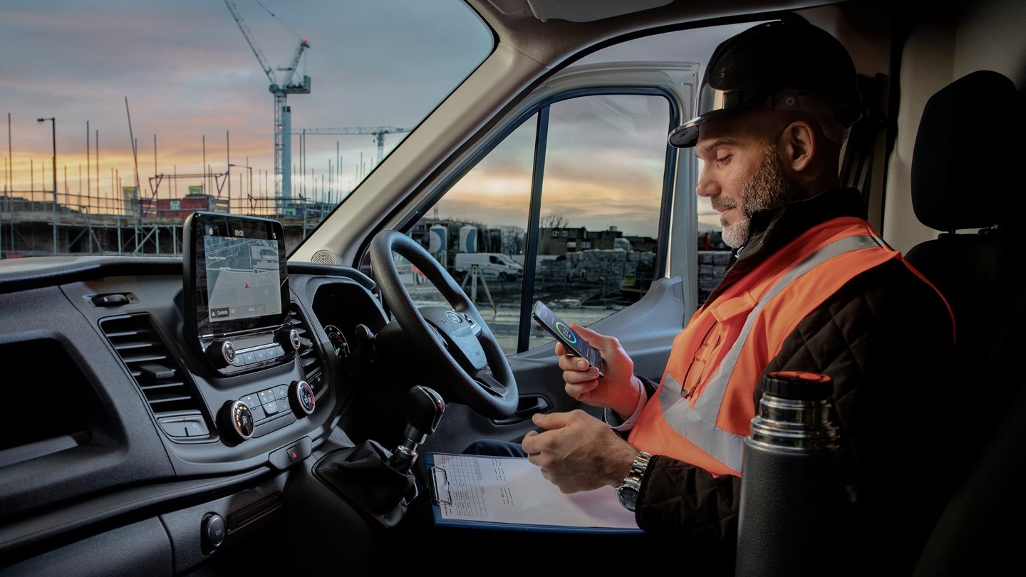 Construction worker in high viz jacket sitting in front seat of  Ford Transit Van