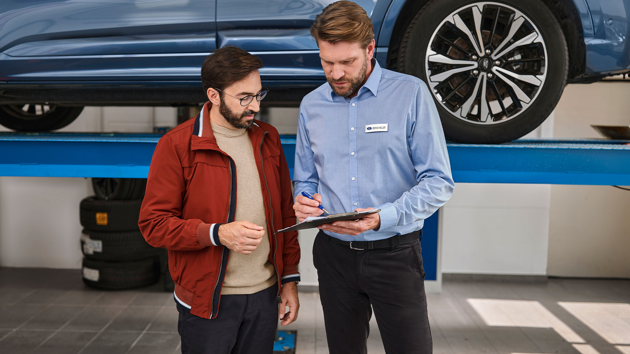 Une personne s'entretenant avec un expert Ford dans un centre de service Ford.