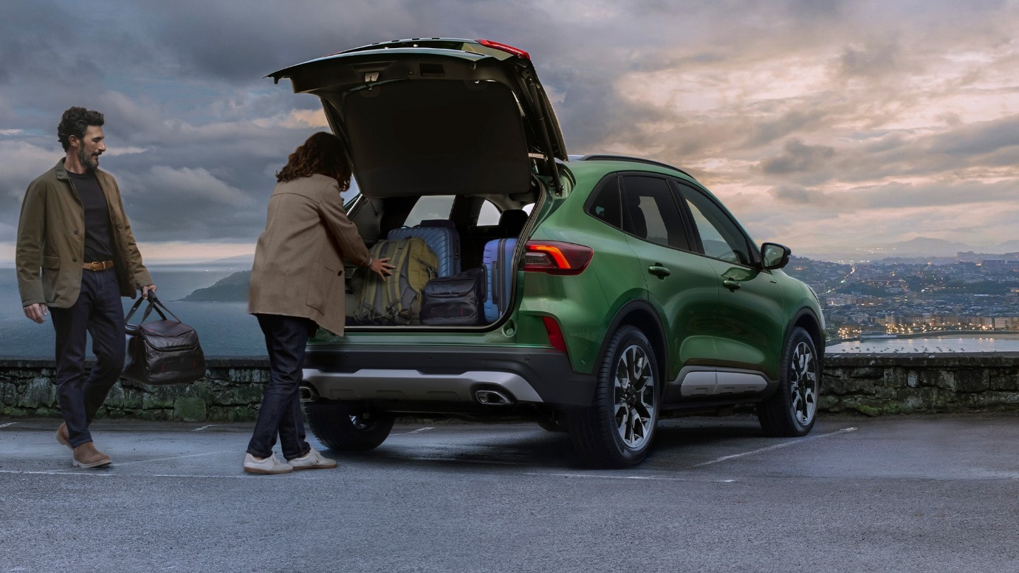 A couple loading baggage into a Ford Kuga A couple loading baggage into a Ford Kuga